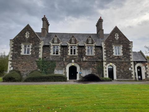 Photograph of a large 19th century building made with grey stone.