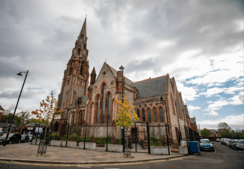 Photograph of a large church built with red bricks. 