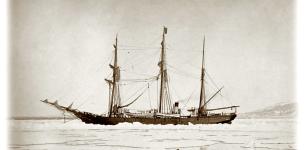 Black and white sketch of a wooden ship with three large masts in a large body of water and hills in the background.