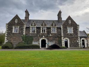 Photograph of a large 19th century building made with grey stone.