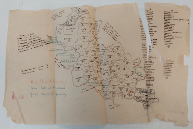 Hand drawn map of land with drawn borders between townlands and a long list of townland names on the right hand side. The page is damaged around the edges and has a large rip on the top right hand side.