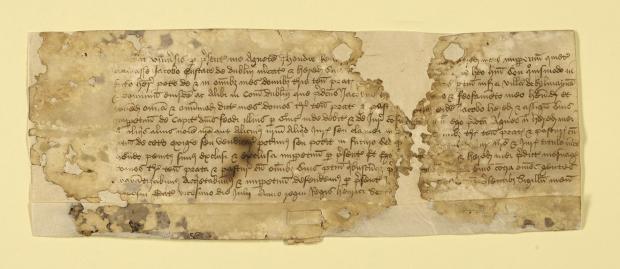 Small archival document with a rip down the middle attached to archival paper and in the middle of yellow archival paper.