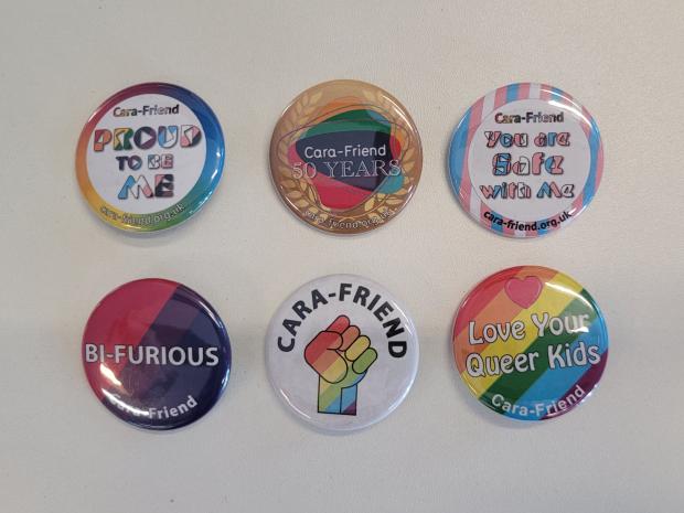Six colourful badges, each of them showing messages supporting Cara-Friend and the LGBTQIA+ community